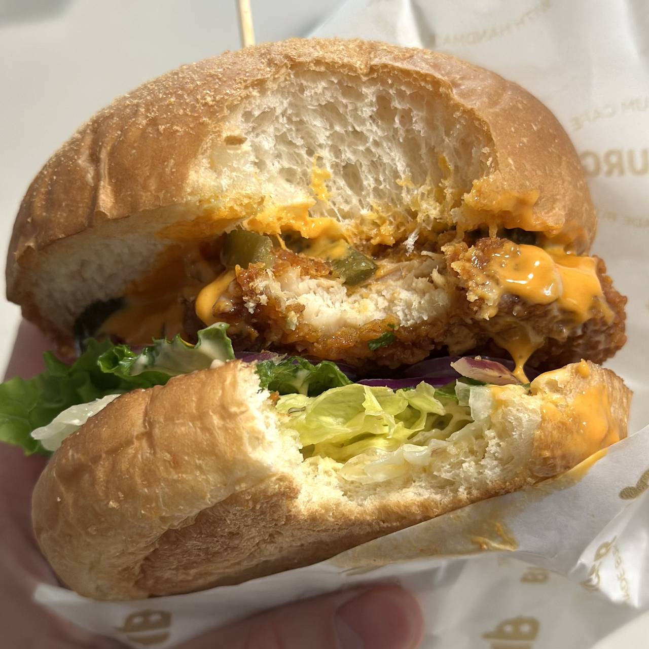 할라피뇨 치킨버거를 한 입 베어 먹은 모습